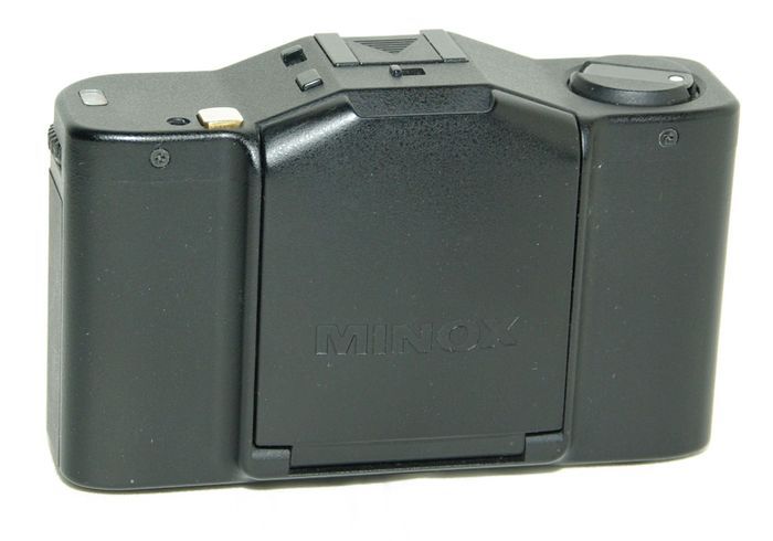 Minox Goldknopf
Période de production : 1991-1993 - Allemagne - n° 70656, série de 720 exemplaires
Type : compact à objectif fixe
Format : 24 x 36 mm sur film 135
Viseur : collimaté avec correction de la parallaxe
Objectif : MC Minoxar 1:2.8 f=35 mm avec filtre incorporé - mise au point de 0,7 m à l'infini
Mesure de l'exposition : automatique avec priorité à l'ouverture par cellule CDS couplée
rappel des vitesses dans le viseur avec zones de sous ou sur-exposition
Double exposition : oui, par interrupteur sur le capot
Sensibilité du film : 25 à 1 600 ASA
Obturateur : central électronique de 30 s à 1/500 s
Retardateur : 10 s, actionné par interrupteur sur le capot
Déclencheur : sur le capot (plaqué or 27 K d'où le nom Goldknopf en allemand) - filetage sur le capot pour déclencheur souple
Synchronisation : X à 1/125 s - contact central sur la griffe
Griffe : oui
Ecrou de pied : oui
Armement : levier à deux manoeuvres - compteur de vues avec remise à zéro lors de l'ouverture du dos
Rembobinage du film : par bouton et manivelle télescopique
Ouverture du dos : par verrou dans l'embase
Dos dateur : D-35G alimenté par 1 pile CR2025
Alimentation : 1 pile PX27 - bouton de test
Dimensions : 100 x 61 x 34 mm
Poids : 190 g
MINOX GOLDKNOPF FERME.jpg