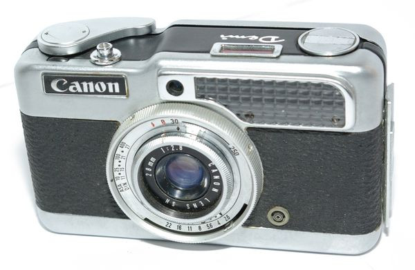 Canon Demi
Période de production : 1963-1964 - Japon - n° 190191
Type : compact zone focus
Format : 18 x 24 mm sur film 135
Viseur : clair non collimaté
Objectif : Canon Lens 1:2,8 f=36 mm - mise au point par icônes
Mesure de l'exposition : posemètre Sélénium couplé
Sensibilité du film : 10 à 400 ASA
Obturateur : central
Déclencheur : sur le capot avec embout fileté pour déclencheur souple ou retardateur
Synchronisation : prise coaxiale en façade
Griffe : non
Ecrou de pied : oui
Armement et avance du film : levier à une seule manoeuvre - compteur de vues avec remise à zéro lors de l'ouverture du dos
Rembobinage du film : par manivelle télescopique
Ouverture du dos : par poussoir sur le côté et charnière
Alimentation : sans
Dimensions : 119 x 70 x 37 mm
Poids : 384 g Canon Demi.jpg
