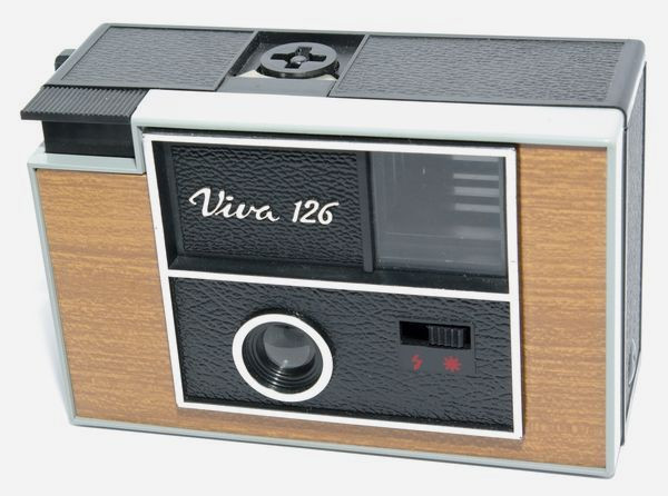 Viva 126 version 1
Période de production : 1980 - France
Variations : décor bois - façade chromée - anneau de dragonne étroit - petit verre
levier d'armement court - presse-film bleu
Format : 28 x 28 mm sur chargeur 126
Viseur : clair
Objectif : ménisque plastique - mise au point fixe de 1,2 m à l'infini
Mesure de l'exposition : sans
Réglages : soleil et flash
Obturateur : central à secteur sans armement préalable
Déclencheur : sur le capot
Flash : griffe pour Flashcube
Ecrou de pied : non
Armement : levier à une seule manoeuvre
Ouverture du dos : par poussoir sur le côté
Alimentation : 2 pile AA de 1,5 v
Dimensions : 118 x 73 x 54 mm
Poids : 160 g Indo Viva 126 v1 37.jpg